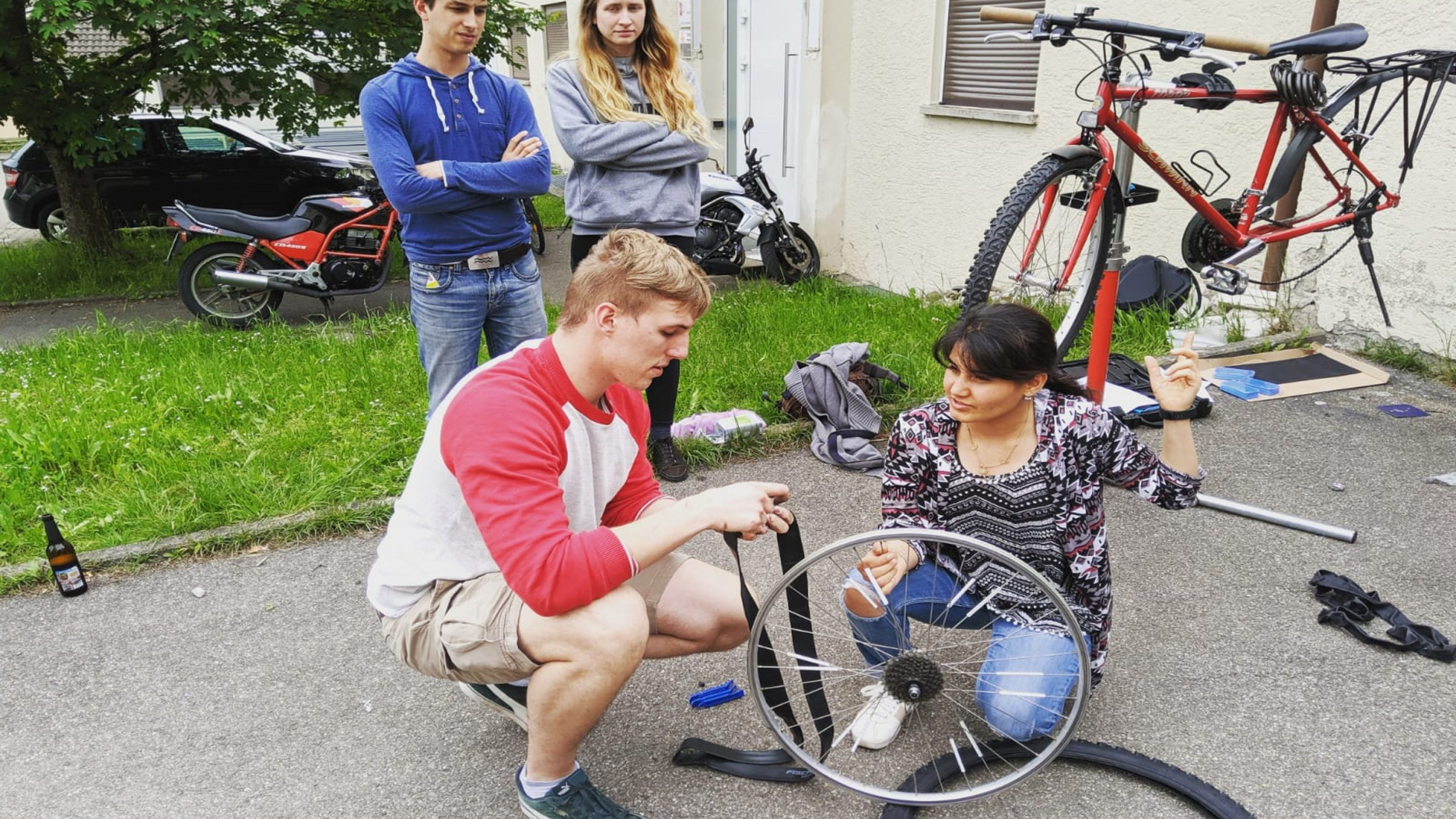 Michael wechselt gemeinsam mit einer Studentin einen kaputten Fahrradschlauch