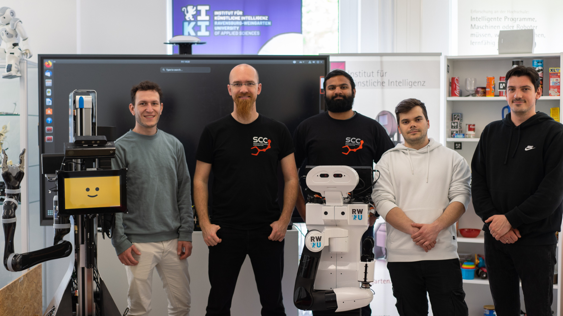RoboLab Team der RWU und zwei Roboter im Institut für Künstliche Intelligenz