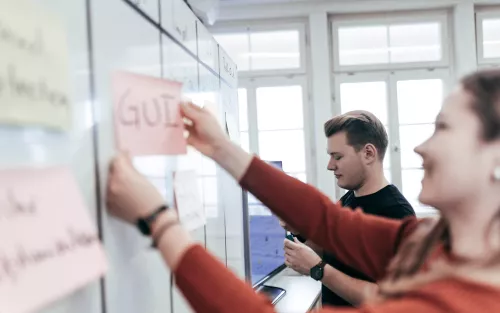 Leute bringen Karten an Flipchart