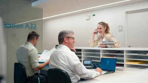 2 Männer und eine Frau am Empfang einer Praxis