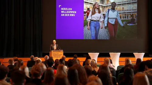 Erstsemesterstudierende bei der Erstsemesterbegrüßung im Kultur- und Kongresszentrum und Rektor Prof. Dr. Thomas Spägele am Podium.