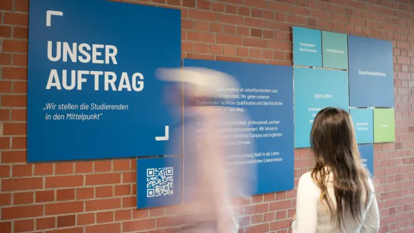 Zwei Personen stehen vor dem Leitbild