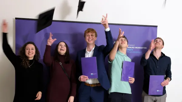 Absolvent*innen werfen Bachelor-Hut in die Höhe.
