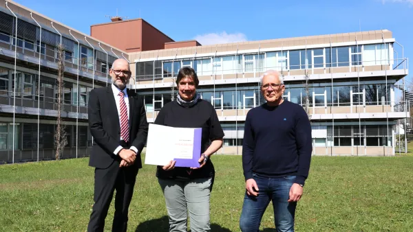 Angelika Bosl erhält zu ihrem 25-jährigen Dienstjubiläum eine Dankesurkunde von Rektor Professor Dr. Thomas Spägele (links) und Kanzler Henning Rudewig (rechts).