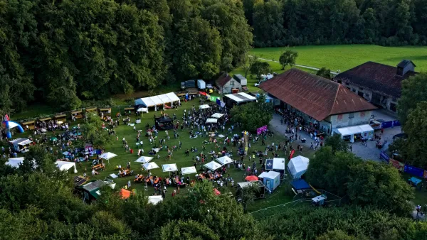 Auf dem Bild ist das Festivalgelände des U&D Weingartens zu sehen: Bühne, Häuser, Essens- und Getränkestände und viele Menschen.