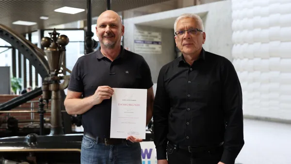Christoph Weber mit seiner Dankesurkunde zum 25-jährigen Dienstjubiläum mit Kanzler Henning Rudewig.
