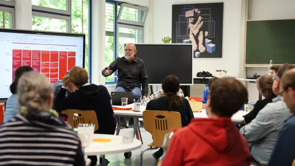 Prof. Stefan Benke an einem Screen mit Workshop-Teilnehmer*innen