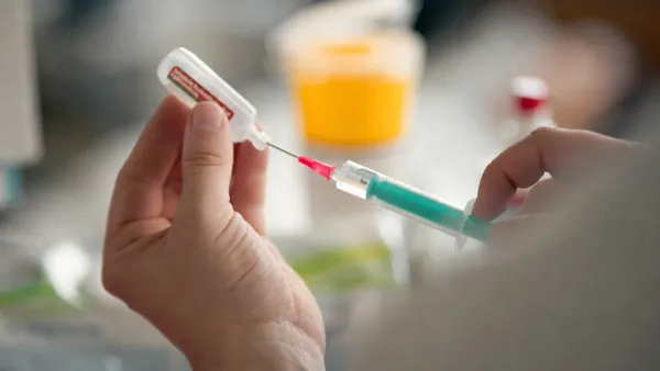 Nahaufnahme von Händen einer Physician Assistant-Studentin beim Aufnehmen einer Injektion aus einem Vial in eine Spritze