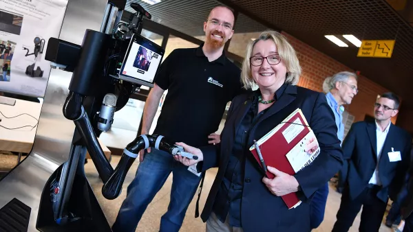 Wissenschaftsministerin Theresia Bauer schüttelt Marvin, dem hochschuleigenen Roboter die Hand.