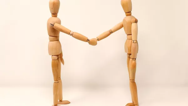 Zwei Figuren reichen sich die Hand