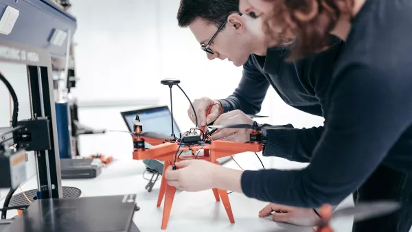 Zwei Studierende basteln an einem Roboter