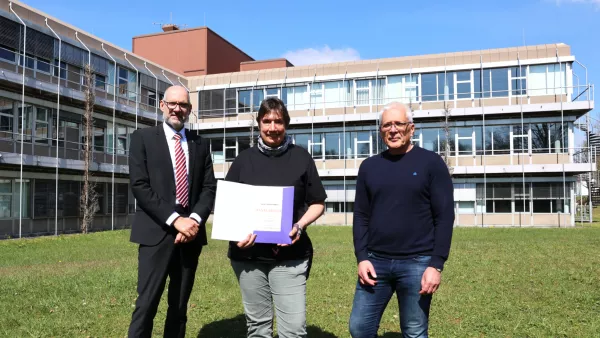 Angelika Bosl erhält zu ihrem 25-jährigen Dienstjubiläum eine Dankesurkunde von Rektor Professor Dr. Thomas Spägele (links) und Kanzler Henning Rudewig (rechts).