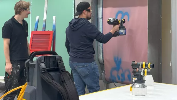 Ein Student aus dem Bereich Digital Business probieren im Rahmen eines Firmenbesuchs bei Wagner in Markdorf Farbsprühsysteme aus.