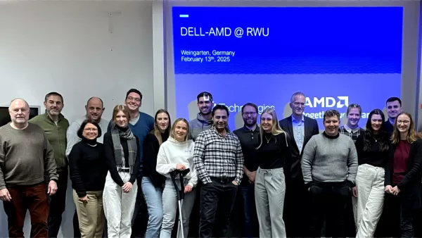 Ein Gruppenfoto von Studierenden und Lehrenden, im Hintergrund befindet sich eine Präsentation.