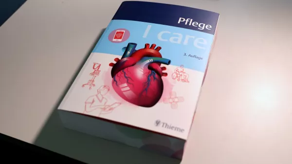 Ein Buch mit dem Titel "Plege. I care" liegt auch einem weißen Tisch