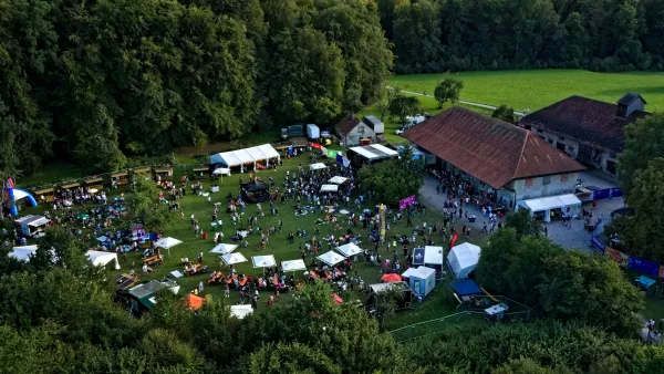 Auf dem Bild ist das Festivalgelände des U&D Weingartens zu sehen: Bühne, Häuser, Essens- und Getränkestände und viele Menschen.