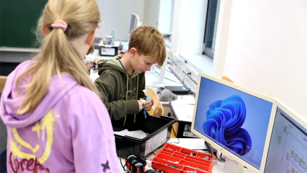 Schüler*innen bauen gemeinsam an einem kleinen Roboter 