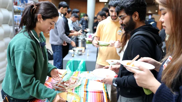 Studentin verteilt Kuchen an Studierende