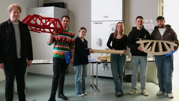 Gewinnergruppen stehen für ein Gruppenfoto mit ihren Brücken zusammen. 