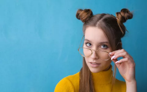 Frau mit Brille vor blauem Hintergrund