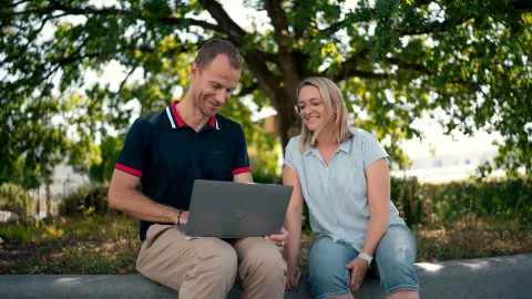 2 Personen im Freien mit Laptop