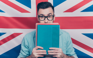 Mann mit Büchern vor englischer Flagge